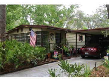 Charming single-story home featuring a carport and well-manicured landscaping with an American flag at 518 W Plantation Blvd, Lake Mary, FL 32746