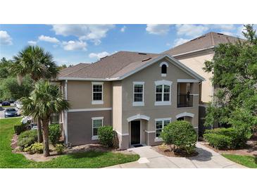 Charming multi-story condo with neutral stucco, white trim, and manicured landscaping under a blue sky at 6512 Swissco Dr # 1428, Orlando, FL 32822
