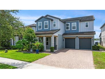 Charming two-story home featuring a manicured front yard and a two-car garage at 7500 Alpine Butterfly Ln, Orlando, FL 32819