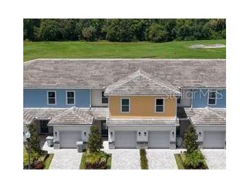 Charming townhomes feature colorful exteriors and individual garages with lovely landscaping at 812 Driving Range Ct, Reunion, FL 34747