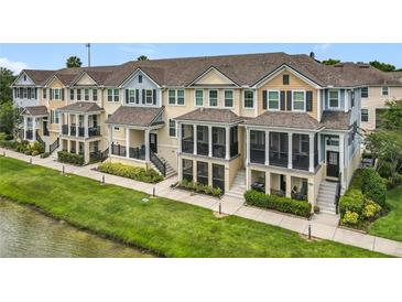 Townhomes with screened porches and green lawns along a pond offer a serene exterior with outdoor living spaces at 1027 Cedar Bay Ln, Winter Springs, FL 32708