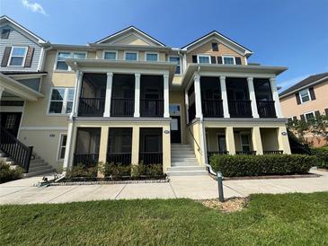 A charming, two-story townhome showcasing dual front porches and manicured landscaping at 1027 Cedar Bay Ln, Winter Springs, FL 32708