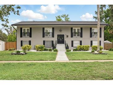 Charming two-story home with a manicured lawn and decorative shutters, exudes classic curb appeal at 103 Cherry Hill Cir, Longwood, FL 32779