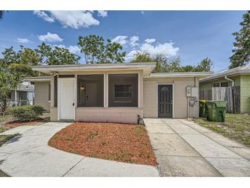 Charming single-story home featuring a screened porch and a tidy front yard with mulch at 108 N Truett St, Leesburg, FL 34748
