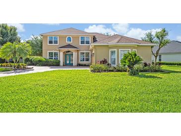 Charming two-story home with a well-manicured lawn, lush landscaping, and a beautiful paver driveway at 14545 Braddock Oak Dr, Orlando, FL 32837