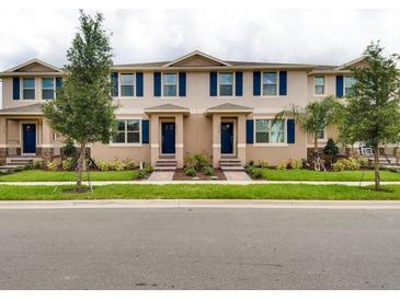 Charming townhomes with blue shutters and landscaping, offering a welcoming curb appeal at 1566 Dalehurst Ln, Kissimmee, FL 34744