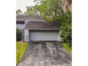 Charming home featuring an attached two-car garage and a well-maintained driveway and mature trees at 209 Sweet Gum Way, Longwood, FL 32779
