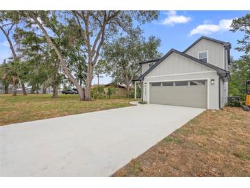 Two story home with a gray exterior, a front-facing two-car garage, and a long concrete driveway at 2137 Brighton Ln, Orlando, FL 32817