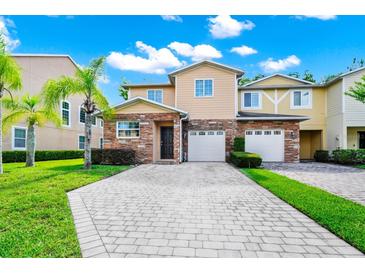 Charming townhome featuring a stone facade, two-car garage, and well-manicured landscaping at 2157 Cypress Villas Dr, Orlando, FL 32825