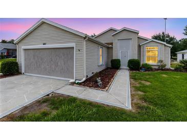 Charming home featuring a garage and well-manicured lawn, exuding curb appeal with beautiful walkway at 25409 Waterbrook Ct, Leesburg, FL 34748