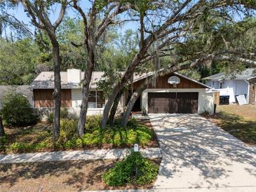 Charming single-story home featuring mature trees, a well-kept lawn, and a convenient two-car garage at 2708 Burton Ln, Orlando, FL 32817