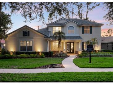 Charming two-story home with a landscaped front yard, illuminated walkway and welcoming double-door entrance at 3352 Park Grove Ct, Longwood, FL 32779