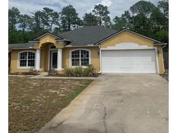Charming single-story home featuring a two-car garage, well-manicured lawn, and inviting architectural details at 701 Twin Lake Ave, Deltona, FL 32738