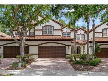 Charming townhome featuring a tile roof, well-maintained landscaping, and a two-car garage at 8414 Frescada Ct, Orlando, FL 32836