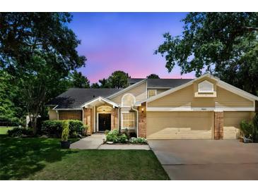 Charming two-story home with a well-maintained lawn, mature trees and a two car garage at 10664 Spring Buck Trl, Orlando, FL 32825