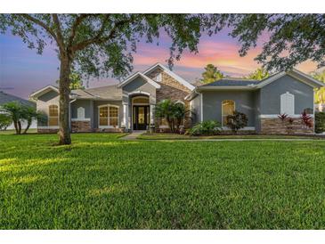 Charming home featuring stone accents, arched windows and lush green lawn at 1333 Killbricken Cir, Ormond Beach, FL 32174
