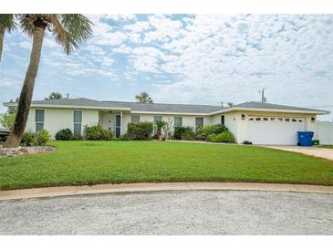 Inviting single-story home featuring a well-manicured lawn and attached two-car garage at 2 Pirates Cv, Ormond Beach, FL 32176