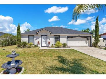 Charming single-story home with well-maintained landscaping and a two-car garage on a sunny day at 2397 Albury Ave, Deltona, FL 32738