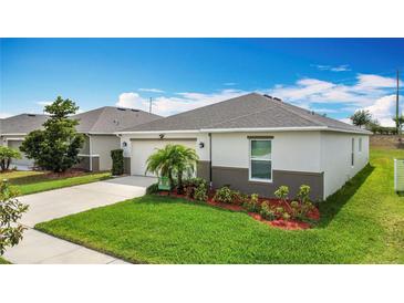 Well-maintained single-story home with a manicured front yard and a driveway leading to a two car garage at 3216 Casa Del Rey Ave, Kissimmee, FL 34746