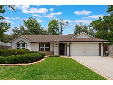 Charming one-story home with a well-manicured lawn and an attached two-car garage at 352 Inglenook Cir, Winter Springs, FL 32708
