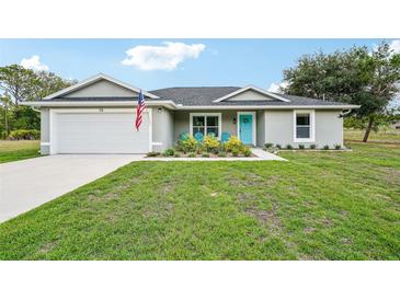 Charming single-story home with well-manicured lawn and a pop of color with the blue door at 38 Malauka Dr, Ocklawaha, FL 32179