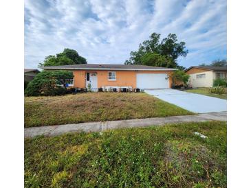 Charming single-story home featuring a light orange exterior and a spacious two-car garage at 4840 Judy Ann Ct, Orlando, FL 32808