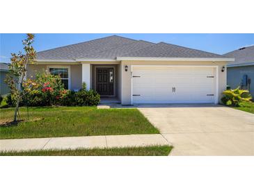 Charming single-story home with a well-manicured lawn and a two-car garage at 871 Orleans Dr, Eagle Lake, FL 33839