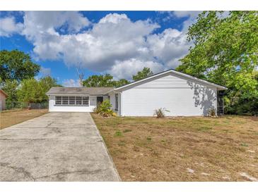 A charming single-story home boasts a long driveway and a well-maintained lawn, perfect for Gathering living at 1340 Bakersfield Ave, Deltona, FL 32725