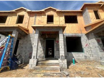 Unfinished townhome with block construction, prepped for finishes and featuring a covered entryway at 15345 Burgtheater Dr, Winter Garden, FL 34787