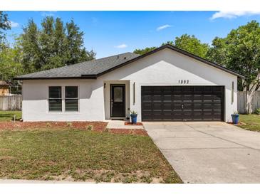 Charming single-story home featuring a two-car garage, fresh paint, and tidy landscaping at 1552 Whooping Dr, Groveland, FL 34736