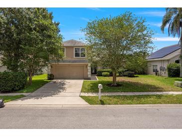 Charming two-story home with a well-manicured lawn, mature trees, and an attached two-car garage at 2853 Strand Cir, Oviedo, FL 32765