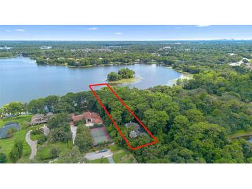 Breathtaking aerial view of a lakefront property with mature trees, offering serene privacy and natural beauty at 4107 Gabriella Ln, Winter Park, FL 32792