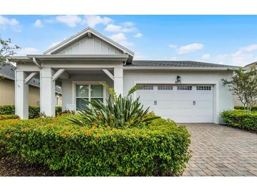 Charming single-story home featuring a well-manicured lawn and a bright white garage door at 5013 E Fountainwood Dr, St Cloud, FL 34772