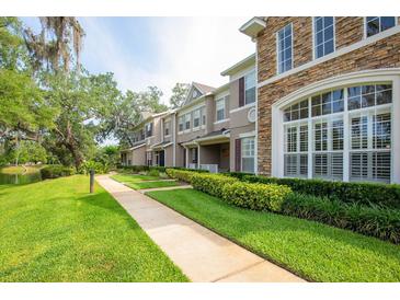 Attractive multi-story home with stone accents, a manicured lawn, and a sidewalk leading to the entrance at 804 Challis Pt, Longwood, FL 32779