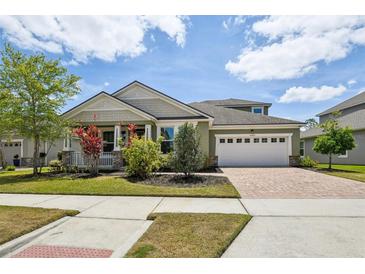 Charming single-Gathering home featuring a well-manicured lawn, brick-paved driveway and lush, colorful landscaping at 8420 Corkfield Ave, Orlando, FL 32832