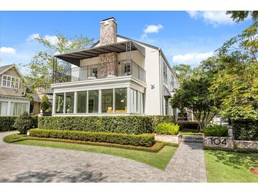 Charming two-story home featuring a balcony, manicured lawn, and brick accents at 104 Cortland Ave, Winter Park, FL 32789