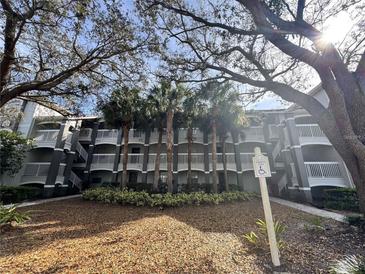 Condo building featuring multiple stories with balconies and a well-maintained landscape at 14025 Fairway Island Dr # 335, Orlando, FL 32837