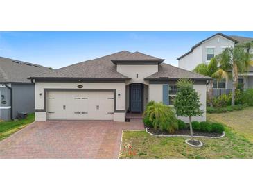 Charming single-story home featuring a brick driveway and well-manicured landscaping at 17199 Hickory Wind Dr, Clermont, FL 34711