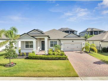 Charming single-story home showcasing a brick driveway, well-maintained landscaping, and a welcoming entrance at 17333 Hickory Wind Dr, Clermont, FL 34711