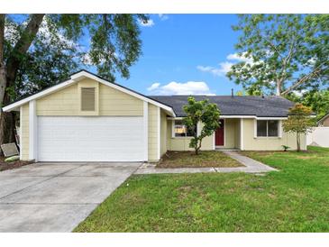 Charming single-story home featuring a red front door, a two-car garage and a well-maintained front yard at 1816 Haperon St, Apopka, FL 32703