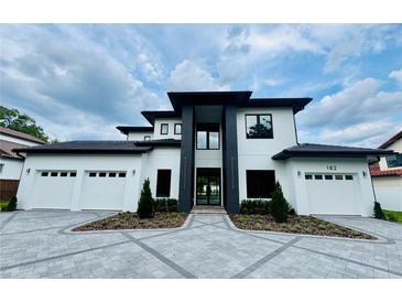 Stunning modern home with a three-car garage, a geometric paver driveway and professional landscaping at 182 N Phelps Ave, Winter Park, FL 32789