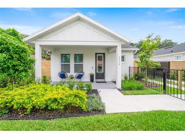 Charming single-story home boasts a well-manicured front yard with lush landscaping and a welcoming front porch at 2110 Hillcrest St, Orlando, FL 32803