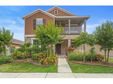 Charming two-story home with a cozy front porch and meticulously landscaped yard at 2136 J Lawson Blvd, Orlando, FL 32824