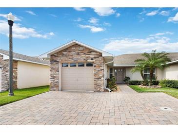 Charming single-story home with a stone-accented facade and a well-manicured lawn with palm tree at 2640 Shelby Ruth Pl, St Cloud, FL 34769
