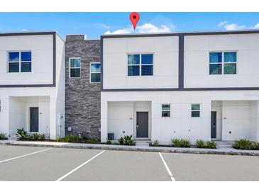 Modern townhome featuring contemporary design, stone accents, and ample parking for residents and guests at 296 Famagusta Dr, Davenport, FL 33896