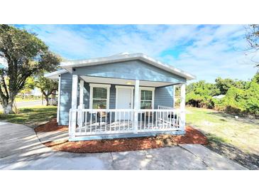 Charming blue home with a white picket porch, perfect for enjoying sunny afternoons at 509 Grove Ave, Orlando, FL 32805