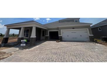 Charming home features a two-car garage, beautiful brick driveway, and a covered porch, blending comfort and curb appeal at 5391 Park Guell St, St Cloud, FL 34771
