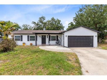 Charming single-story home with white brick, dark trim, and a cozy hanging chair on the front porch at 7741 Pine Hollow Ct, Orlando, FL 32822