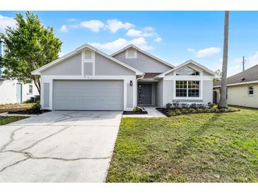 Charming single-story home with gray exterior, well-maintained lawn, and attached two-car garage at 831 Islander Ave, Orlando, FL 32825