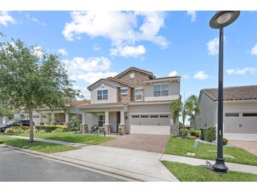Charming two-story home with stone accents, a brick driveway, and an attached two-car garage at 13139 Stanthorne Ave, Orlando, FL 32832